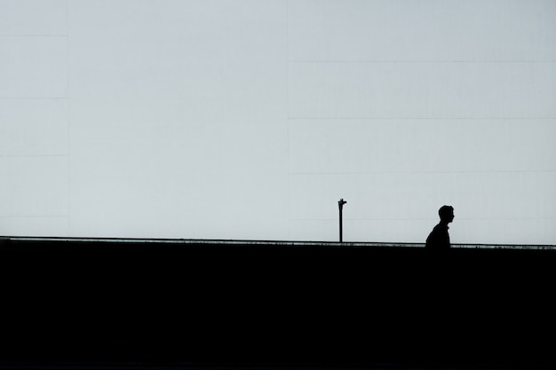 Silhueta horizontal de um homem solitário sob o céu claro