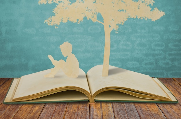 Silhuetas de uma árvore e um homem em um livro