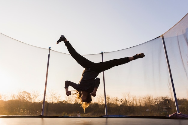 Silueta, de, menina, pular, ligado, um, trampoline, fazendo, divisão