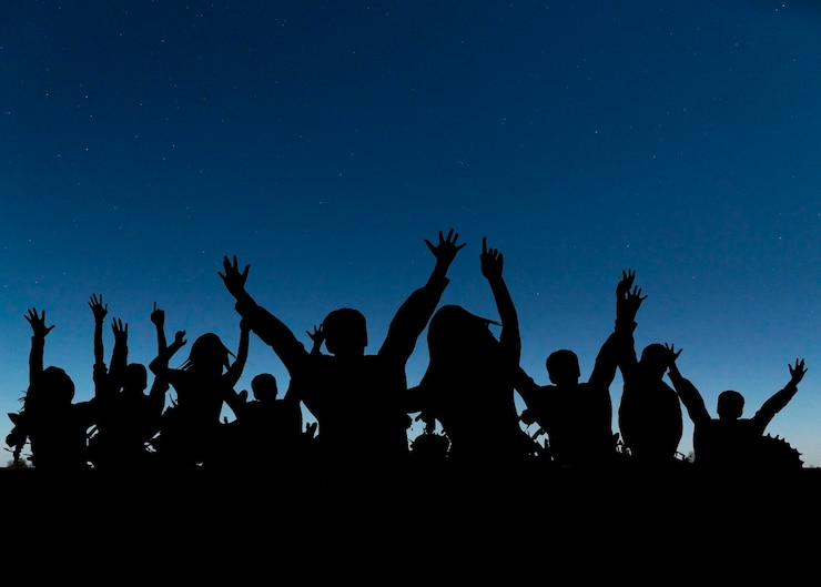 Foto grátis siluetas humanas em tom médio a festejarem juntas.