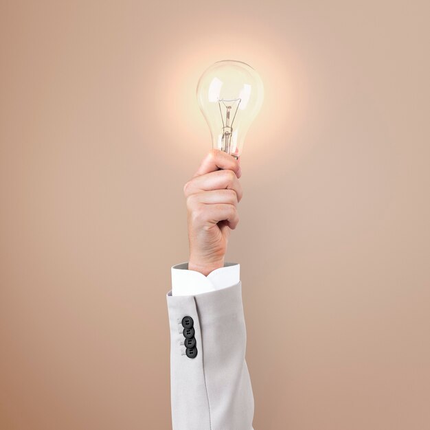 Símbolo de ideia de negócio criativo de lâmpada segurado por uma mão
