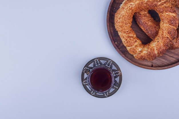 Simit turco em uma bandeja de madeira com um copo de chá, vista superior. Foto de alta qualidade