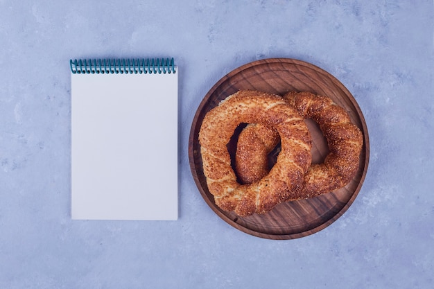 Simit turco em uma bandeja de madeira com um livro de recibos