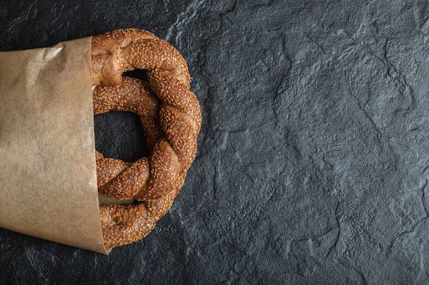 Simit turco recém-assado em fundo preto.