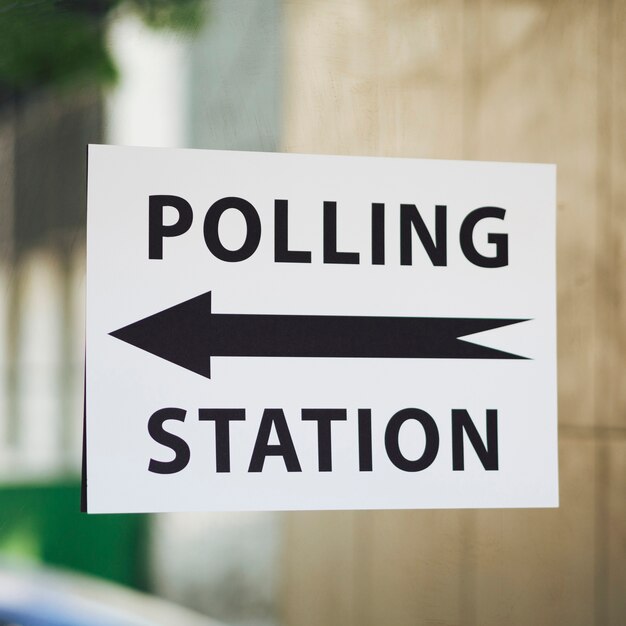 Sinal de estação de voto com direção na janela close-up