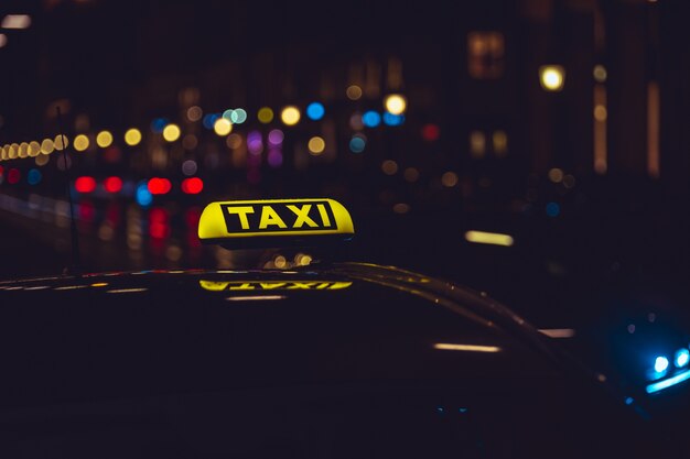 Sinal de táxi no carro durante a noite