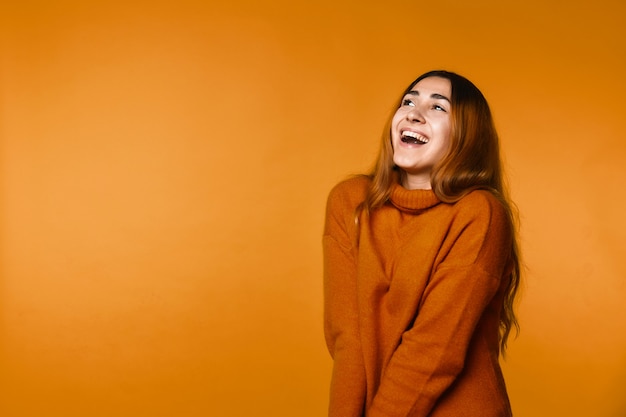 Sinceramente sorridente mulher caucasiana ruiva vestida com pulôver de lã