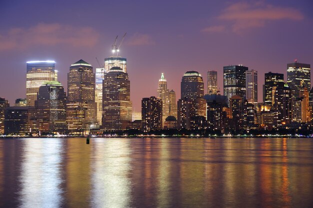 Skyline do centro de Manhattan da cidade de Nova York ao entardecer com arranha-céus iluminados sobre o panorama do Rio Hudson