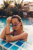 Foto grátis slim graciosa mulher relaxando na piscina