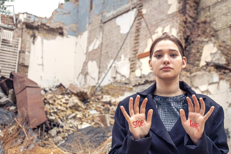 Foto grátis slogan de paz sem guerra está escrito na mão da mulher em vermelho parar a guerra