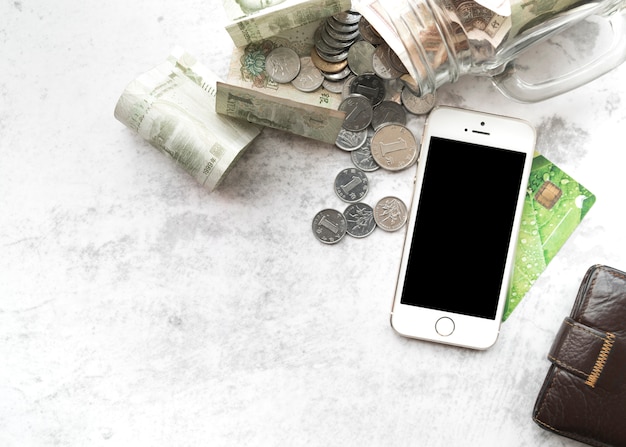 Smartphone com dinheiro, cartão de crédito e carteira