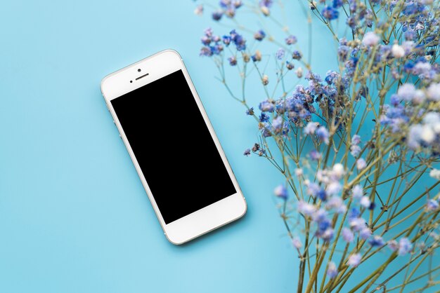 Smartphone e galhos de flores frescas