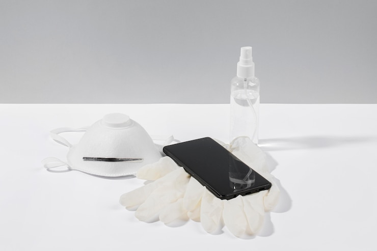 Foto grátis smartphone na superfície com máscara facial e luvas cirúrgicas