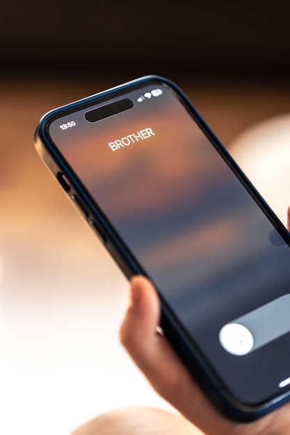 Foto grátis smartphone nas mãos de uma criança com uma chamada recebida de um irmão em uma tela
