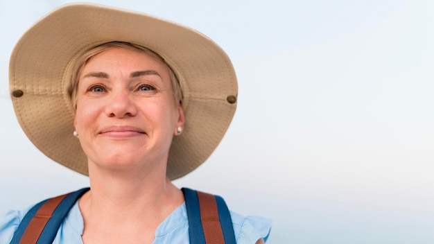 Smiley despreocupada idosa turista com chapéu de praia