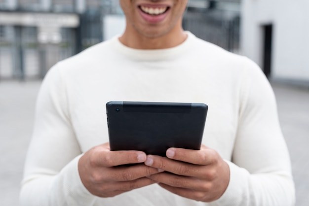 Foto grátis smiley homem adulto segurando um tablet