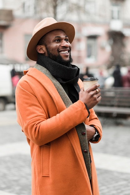 Foto grátis smiley homem bonito segurando uma xícara de café