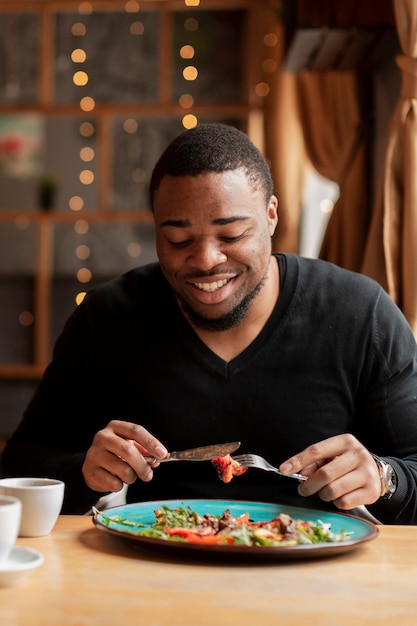 Smiley homem comendo no restaurante