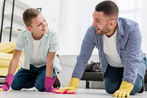 Smiley homem e menino limpando o chão
