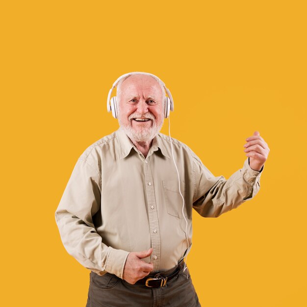 Smiley homem mais velho tocando quitar imaginário