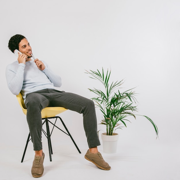 Foto grátis smiley jovem falando ao telefone no escritório