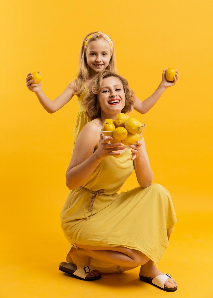 Foto grátis smiley mãe e filha segurando limões
