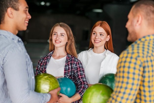 Smiley pessoas em pé em um clube de boliche