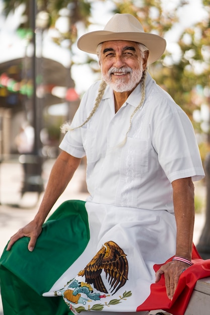 Foto grátis smiley velho com tiro médio de bandeira mexicana