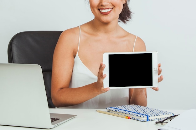 Smiley woman presentin tablet no escritório