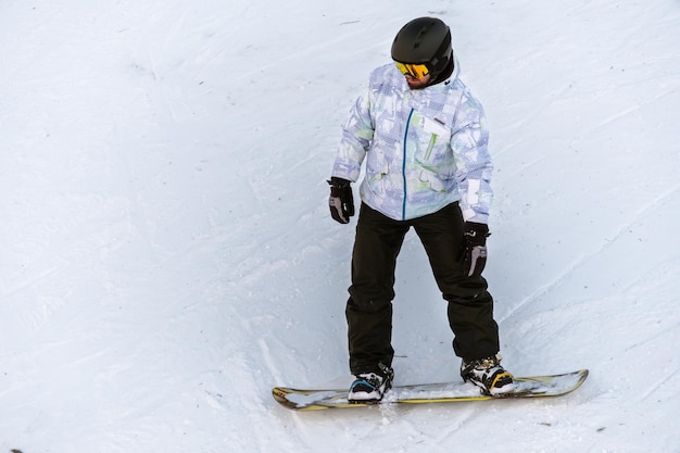 Snowboarder andando em uma pista de esqui nos cárpatos no inverno romênia