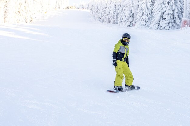 Snowboarder em movimento descendo a colina em um resort nas montanhas