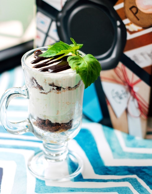 Foto grátis sobremesa cremosa com calda de chocolate em vidro