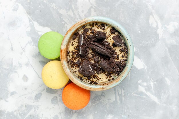 Sobremesa de biscoito de chocolate com macarons franceses em biscoitos de mesa branco-claro