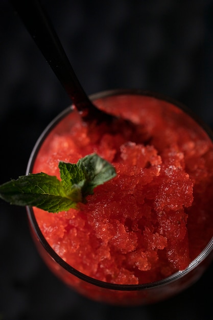 Foto grátis sobremesa de granita de morango de alto ângulo com hortelã