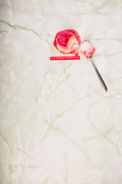 Foto grátis sobremesa de panna cotta com colher em mármore