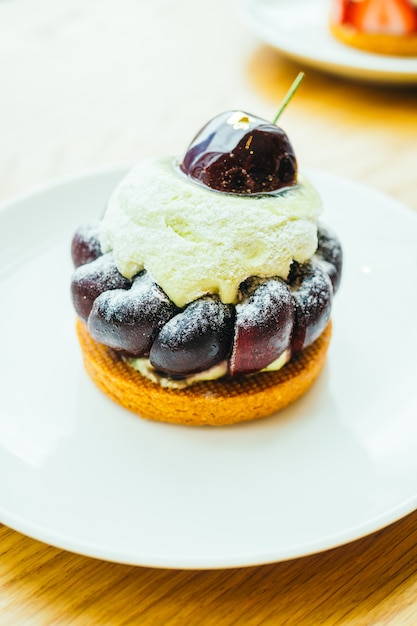 Sobremesa doce com cereja em cima de torta e torta