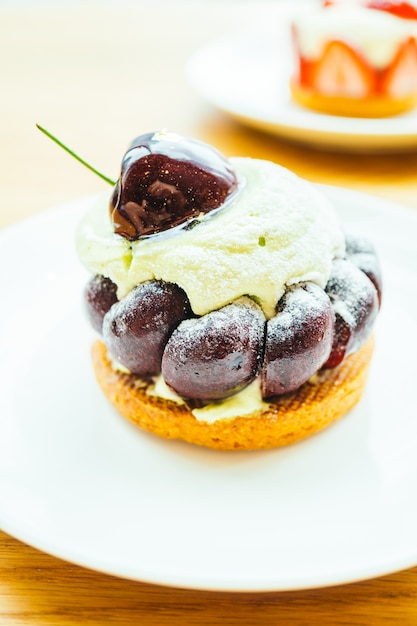 Sobremesa doce com cereja em cima de torta e torta