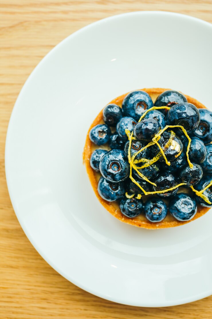 Foto grátis sobremesa doce com tarte de mirtilo em prato branco