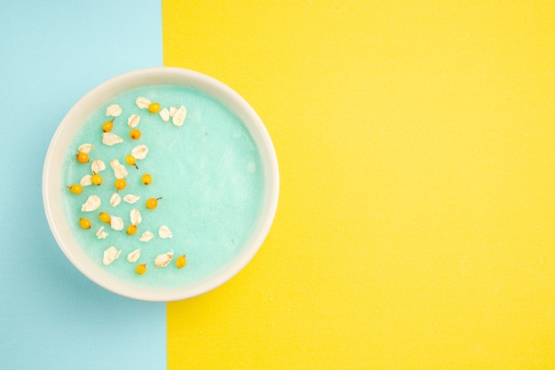 Sobremesa gelada azul vista de cima dentro do prato em cereal de cor de leite de mesa azul-amarelo