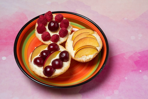 Sobremesas de verão com fatias de frutas e frutas vermelhas em uma travessa decorativa