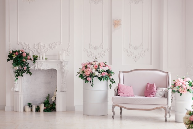 Sofá clássico do estilo de matéria têxtil branca na sala do vintage. barris pintados de flores ob