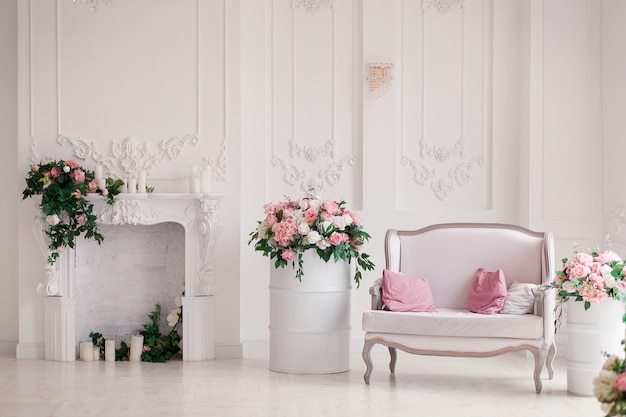 Sofá clássico do estilo de matéria têxtil branca na sala do vintage. Barris pintados de flores ob