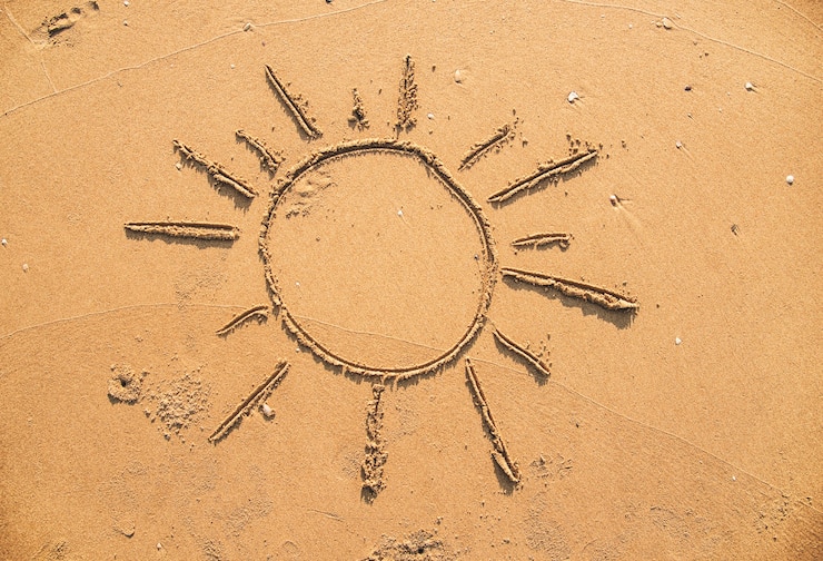 Foto grátis sol desenhado na areia