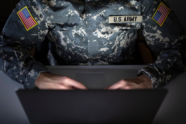 Foto grátis soldado americano irreconhecível em uniforme militar usando computador na comunicação - centro de inteligência para vigilância e proteção de fronteira