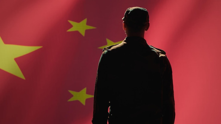 Foto grátis soldado fazendo um gesto de mão de saudação para a bandeira chinesa