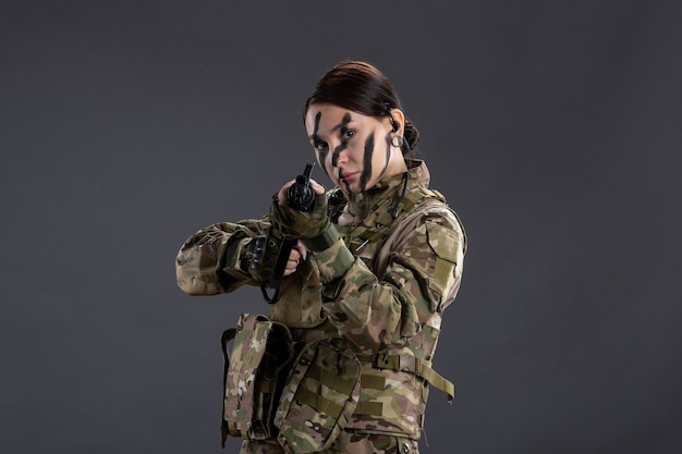 Soldado feminino camuflado com metralhadora na mesa escura tanque guerra israel