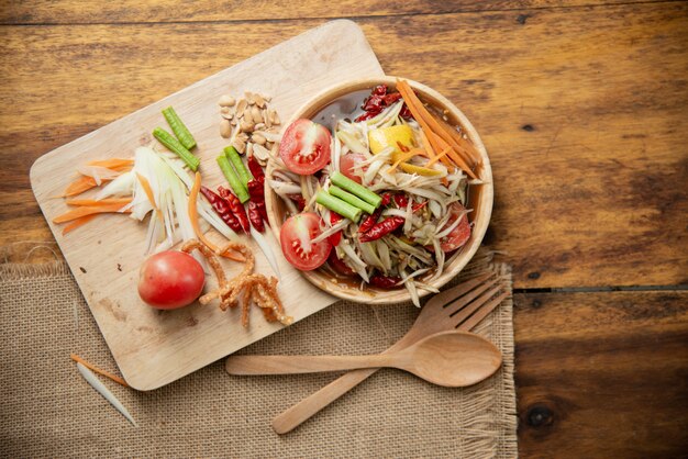 Som Tam tailandês, salada de papaia tailandês em fundo de madeira