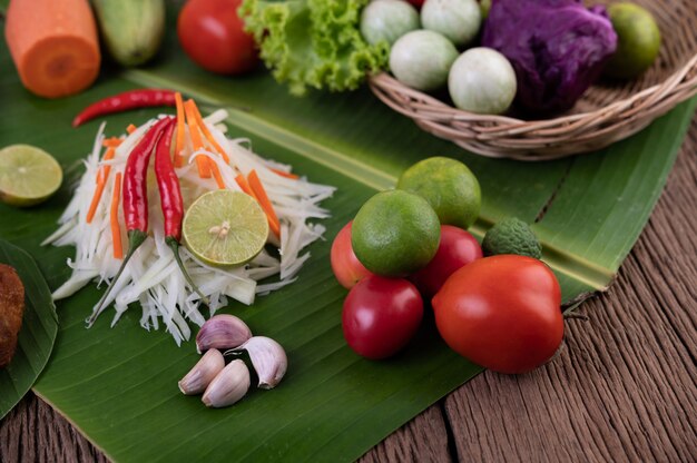 Som Tam Thai - estilo tailandês do alimento da salada da papaia dos ingredientes na tabela de madeira. Conceito de comida tailandesa.