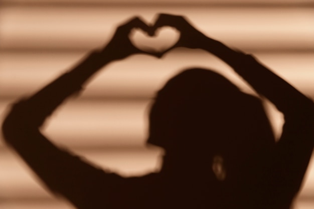 Foto grátis sombra de mulher fazendo um coração