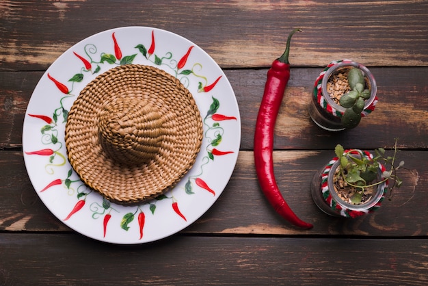 Sombrero na placa perto de plantas em vasos e pimentão